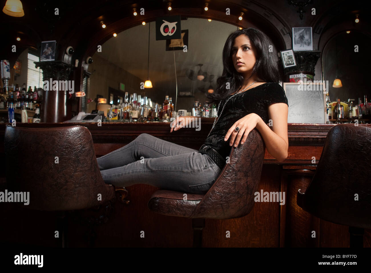 Dark haired girl est assis au bar Banque D'Images