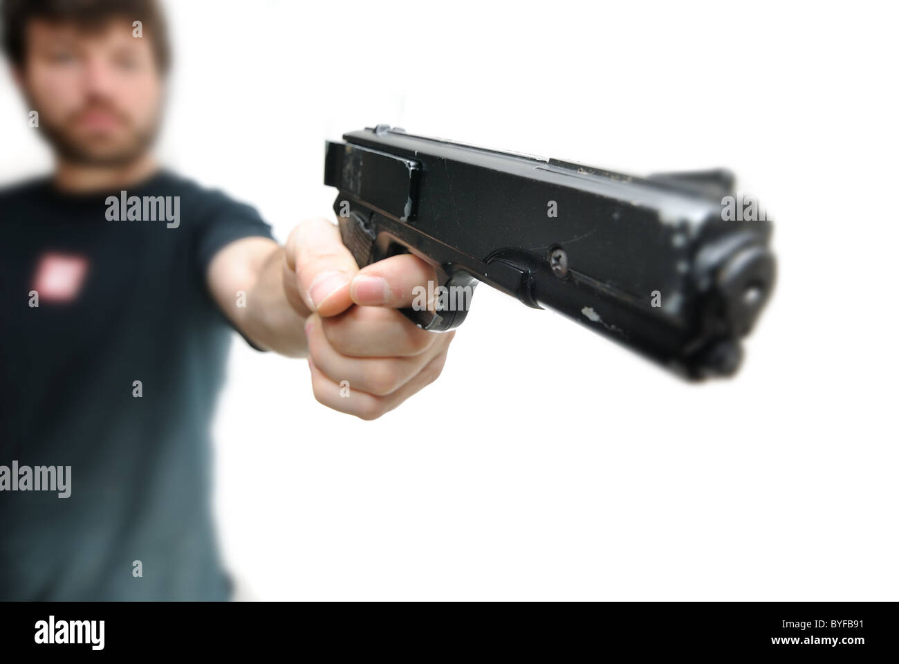 Homme pointant un pistolet isolé sur fond blanc. Banque D'Images