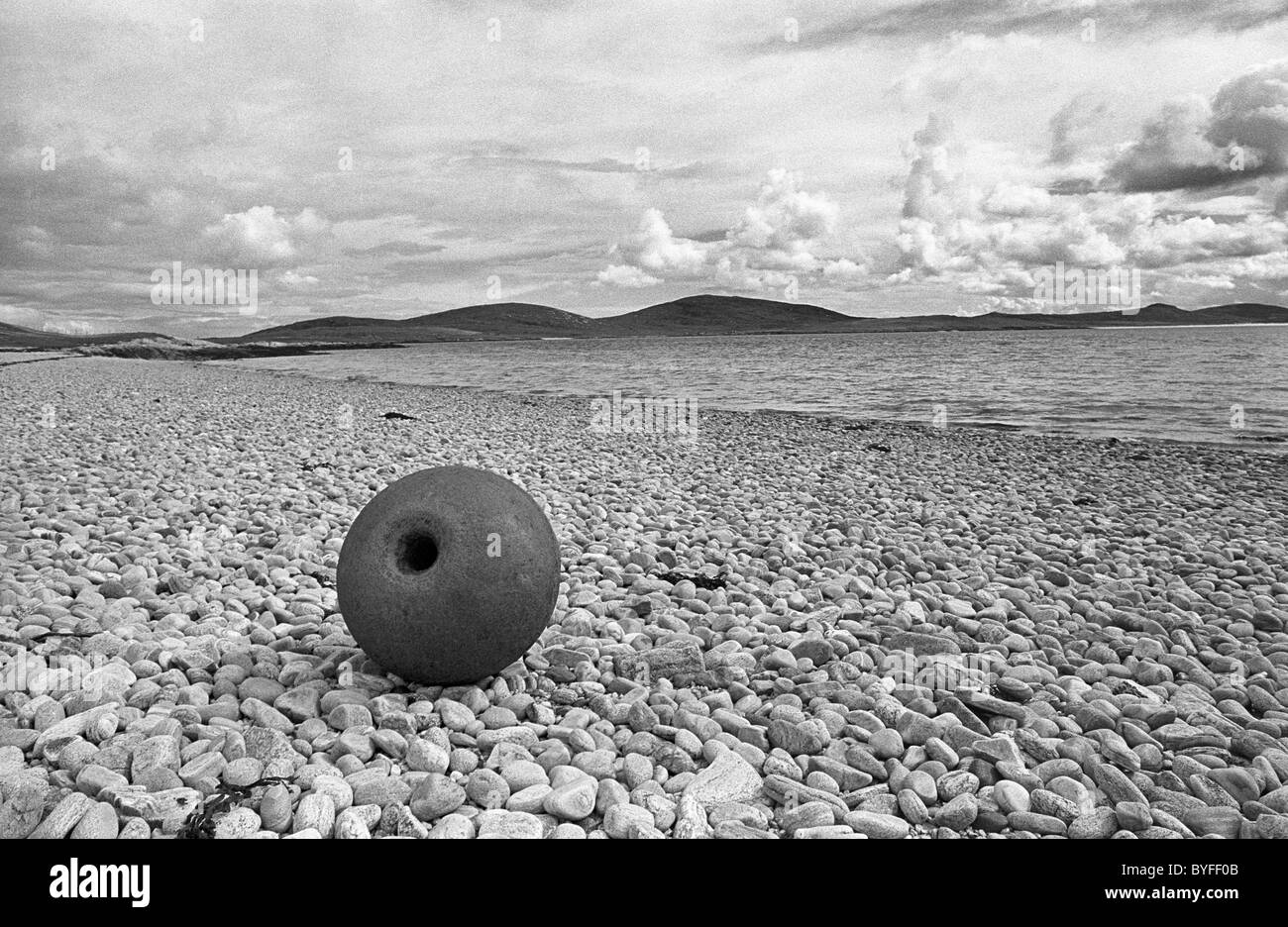 Une bouée de pêche métallique sur une plage de galets sur l'île de Berneray, Hébrides, Ecosse Banque D'Images