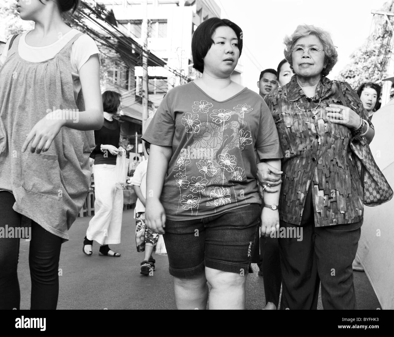 Portrait noir et blanc de la femme marchant le long d'une Thai street market Banque D'Images