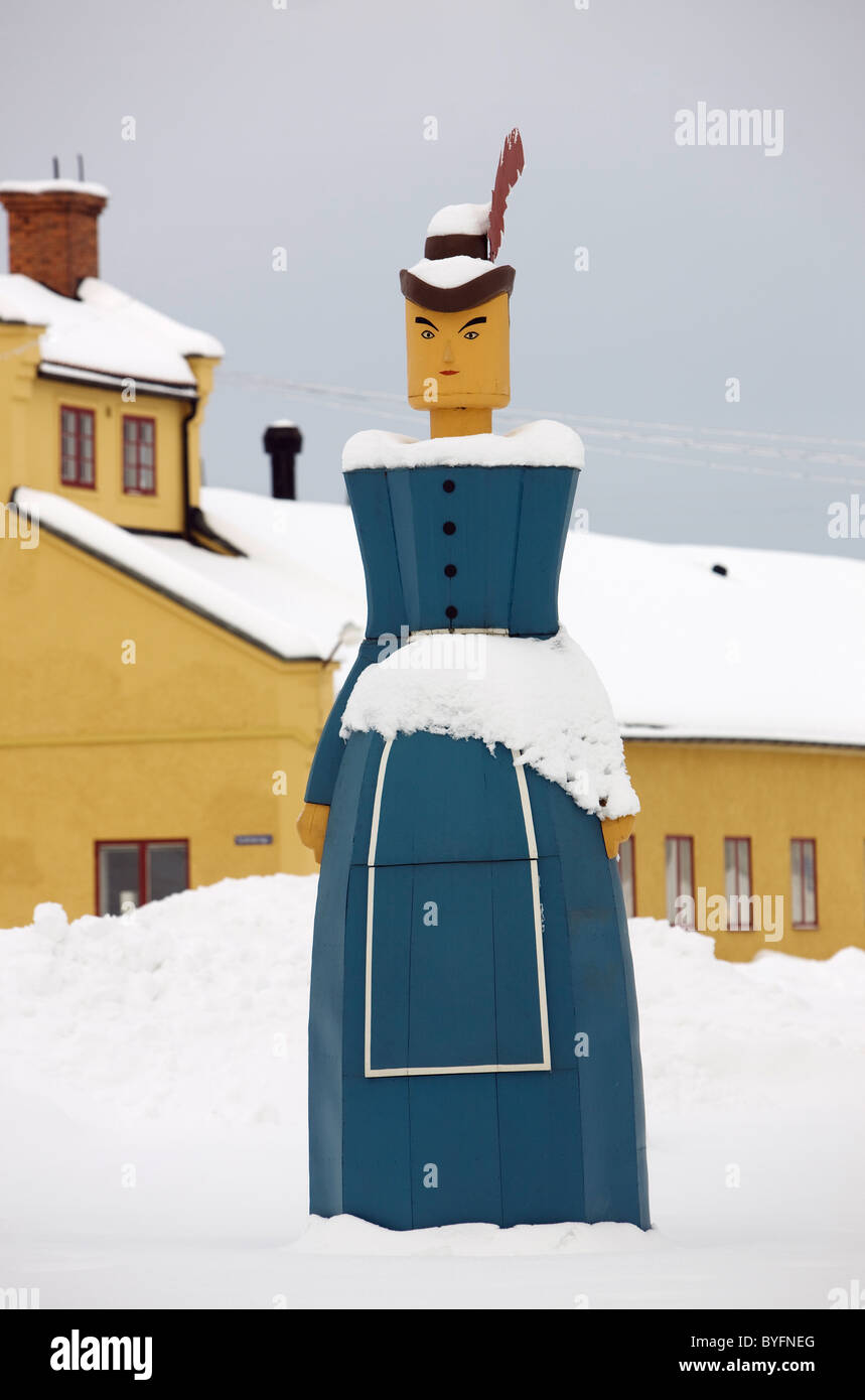 Bâtiment couvert de neige et statue en bois Banque D'Images