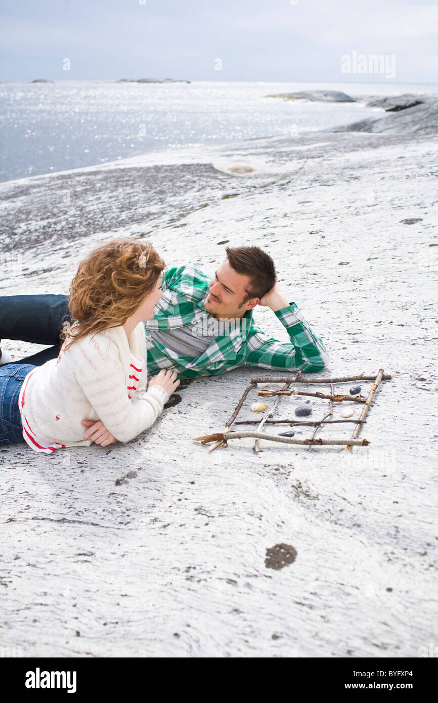 Couple jouant le tic-tac-toe sur beach Banque D'Images