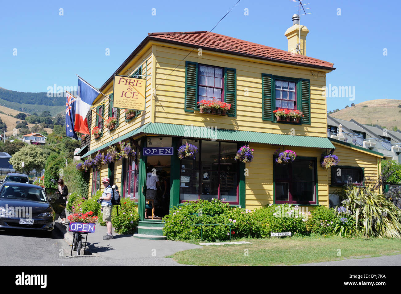 Le tricolore français et le drapeau néo-zélandais suspendus à l'extérieur de la boutique de bijoutier Fire & Ice dans la petite ville historique pittoresque d'Akaroa, et CAN Banque D'Images