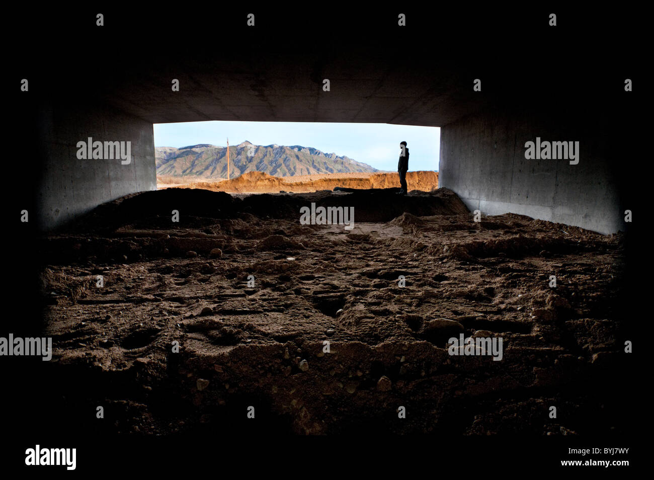 Homme debout à l'entrée du tunnel noir Banque D'Images