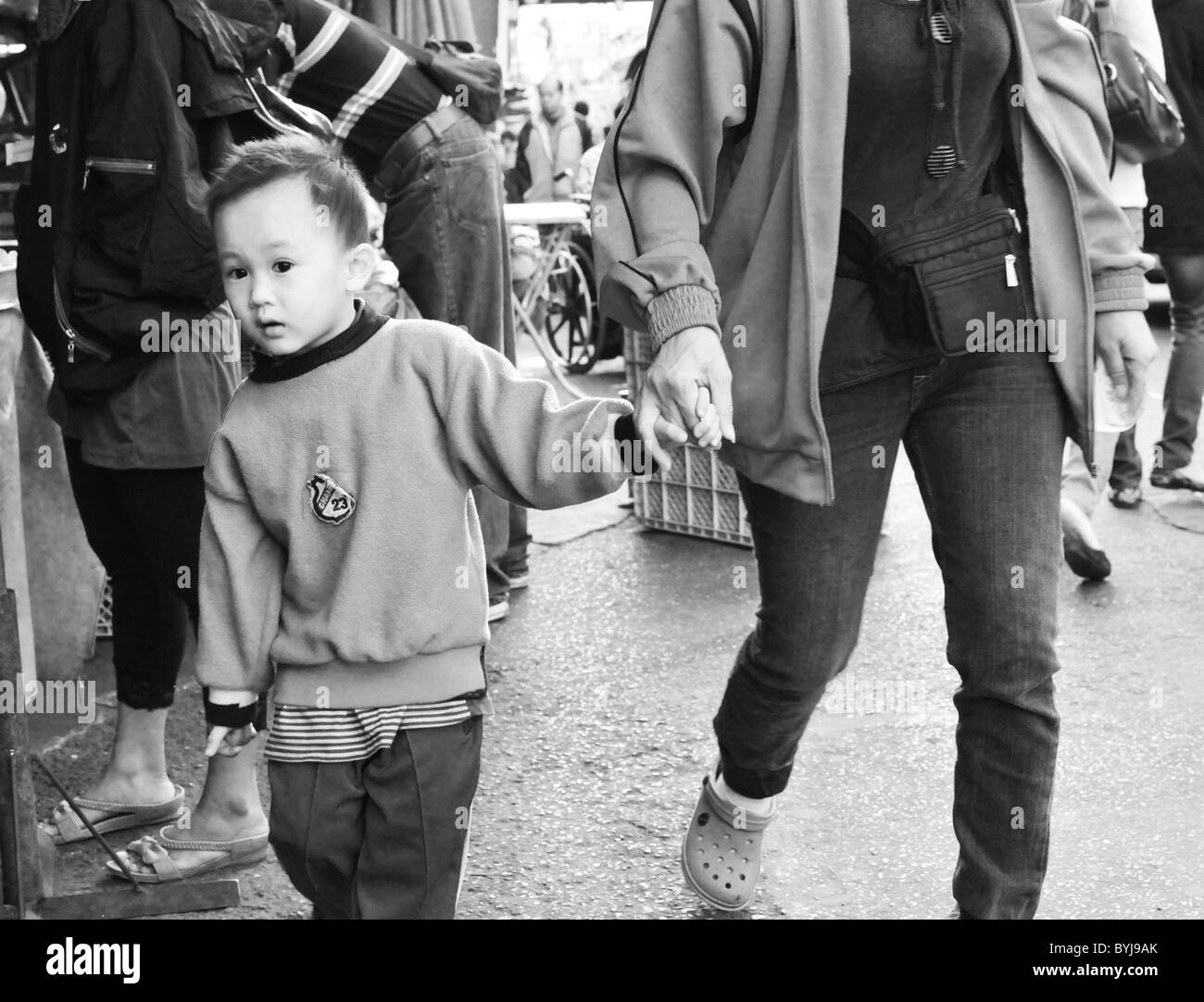 Photographie en noir et blanc d'un jeune garçon thaïlandais à un marché de rue Banque D'Images