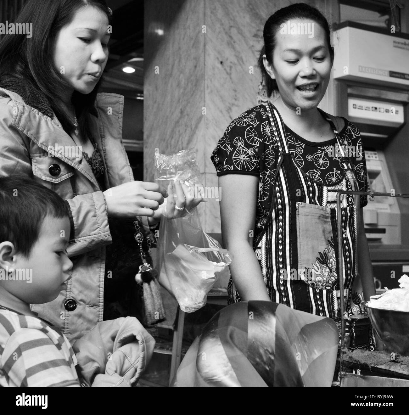 Photographie en noir et blanc d'une mère et son fils shopping dans un marché thaïlandais Banque D'Images