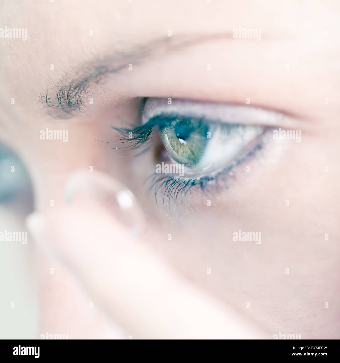 Jeune femme l'insertion d'une lentille de contact dans l'œil, close-up Banque D'Images