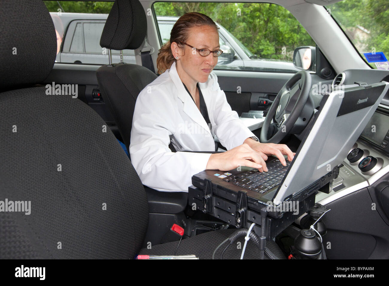 Home health care nurse de sciage dans les données des patients sur une voiture à un ordinateur portable pour un service de soins à domicile basé à Austin, TX Banque D'Images