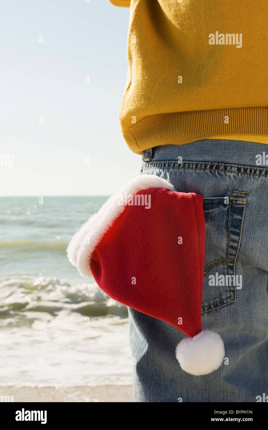 Au beach à la vue, à la Santa hat en poche arrière Banque D'Images