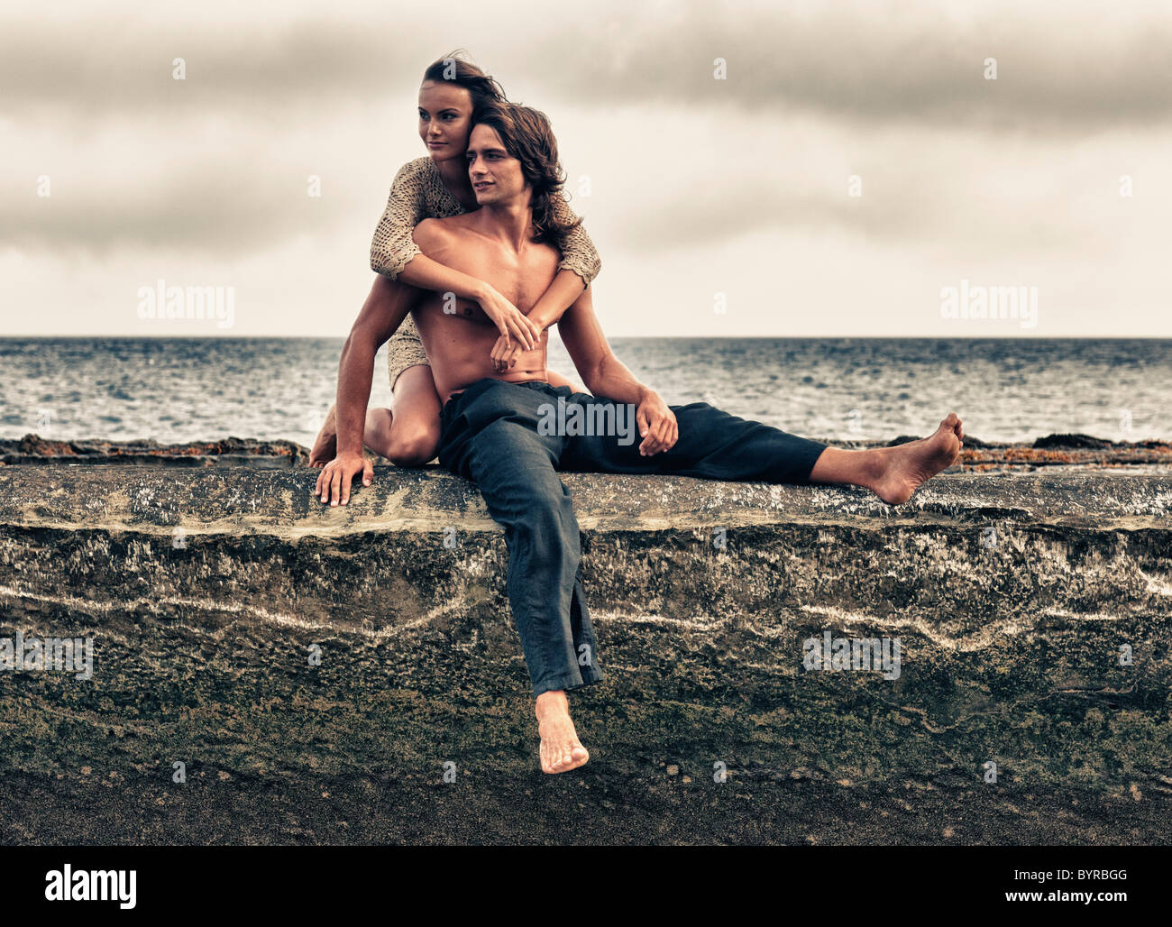 Un homme et une femme assis sur une corniche le long de l'océan dans la région de Parque Natural del Estrecho, Tarifa, Cadix, Andalousie, espagne Banque D'Images