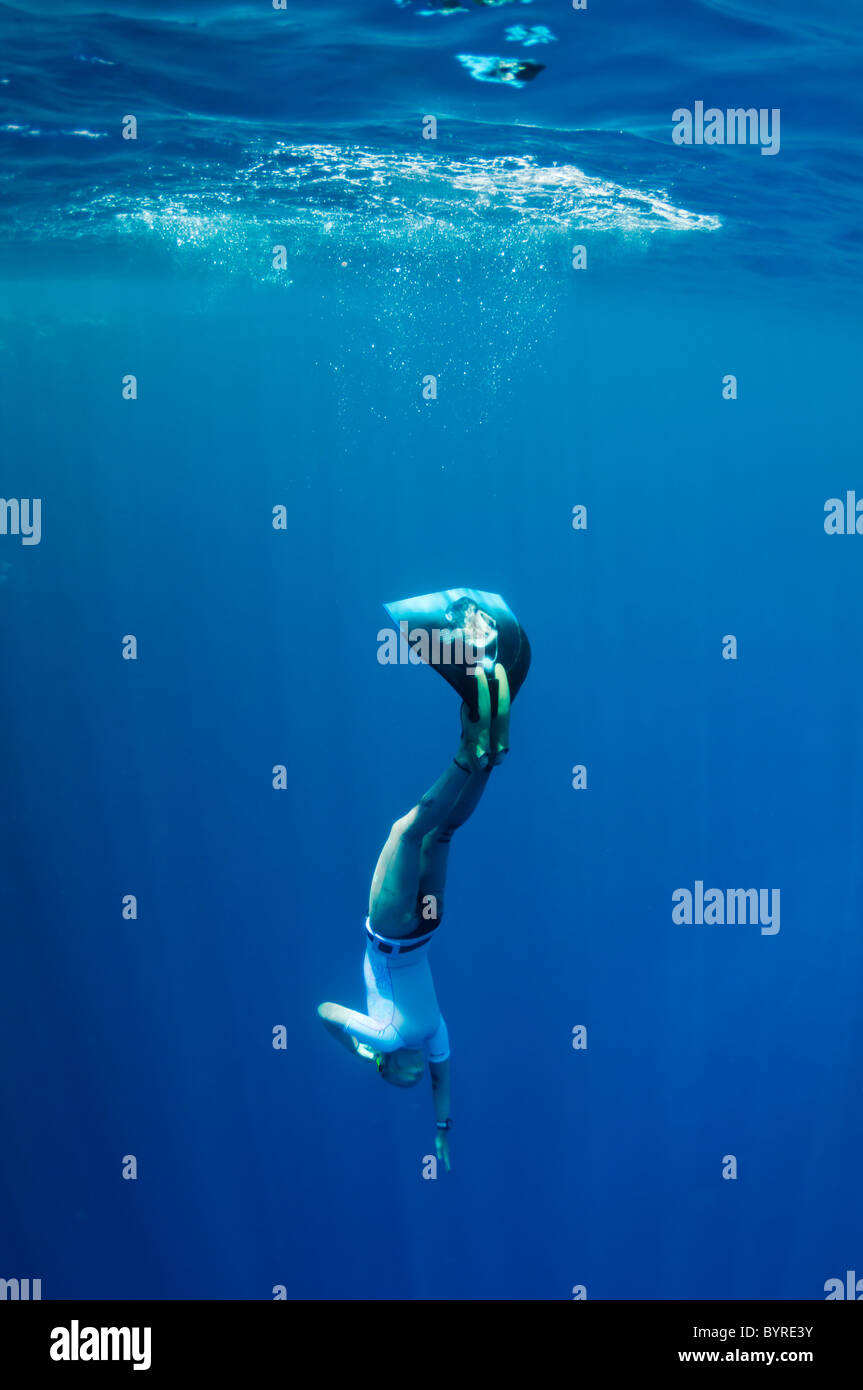 Freediver commence sa plongée à la profondeur de la mer à partir de la surface à la lumière du soleil Banque D'Images