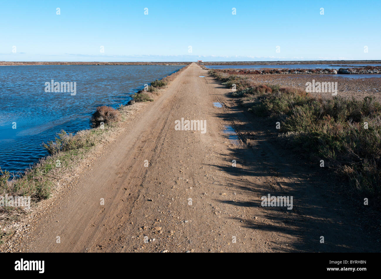 Une piste à travers la zone de production de sel au sud de Gruissan, Languedoc. Banque D'Images