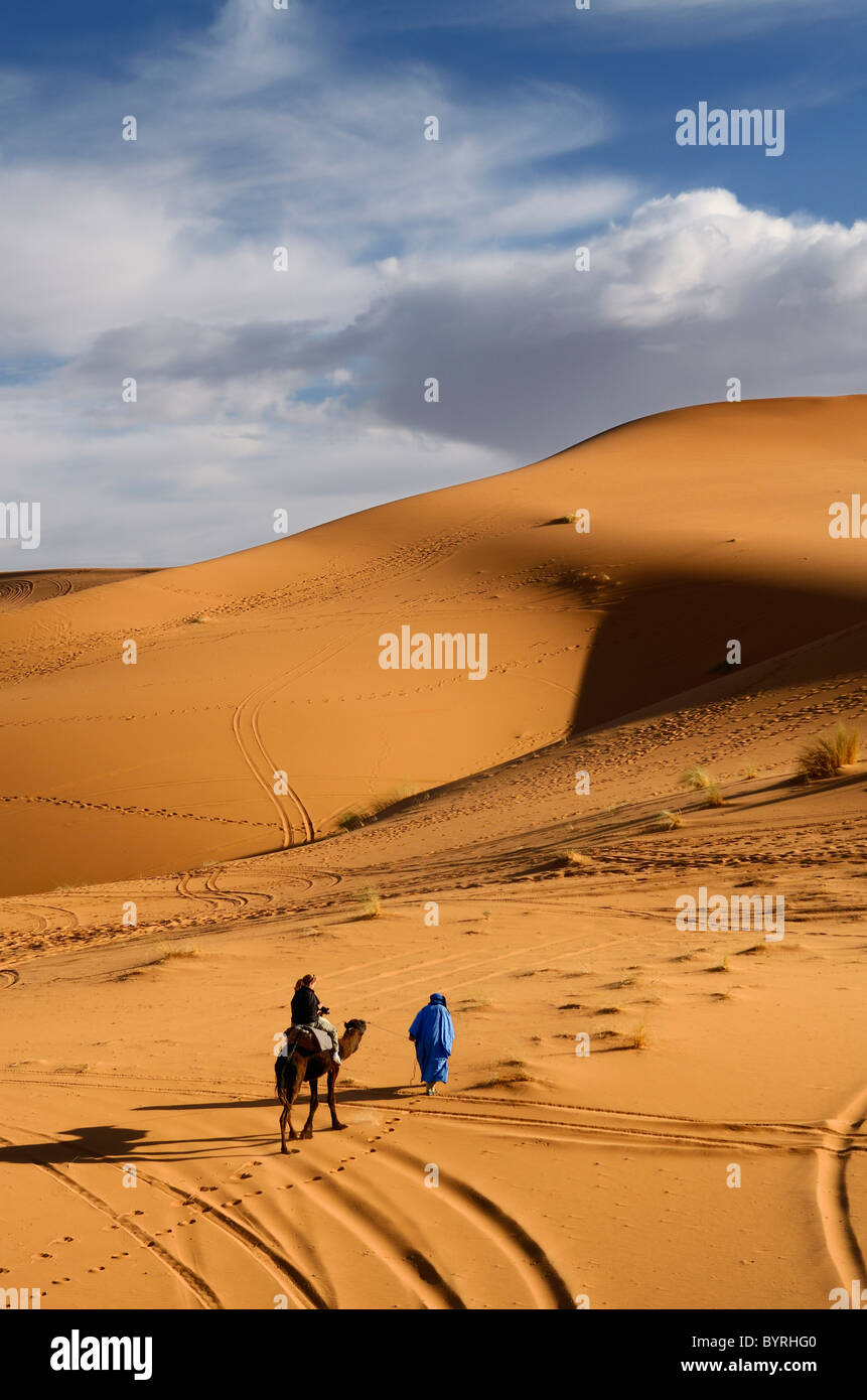 Berbère touareg homme menant un touriste sur dromadaire dans le désert de l'Erg Chebbi au Maroc Afrique du Nord Banque D'Images