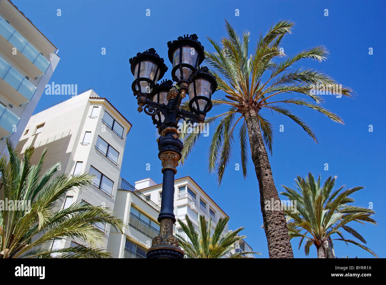La lumière de la rue et de palmiers avec des appartements de luxe en arrière-plan. Lloret de Mar, Espagne. Banque D'Images