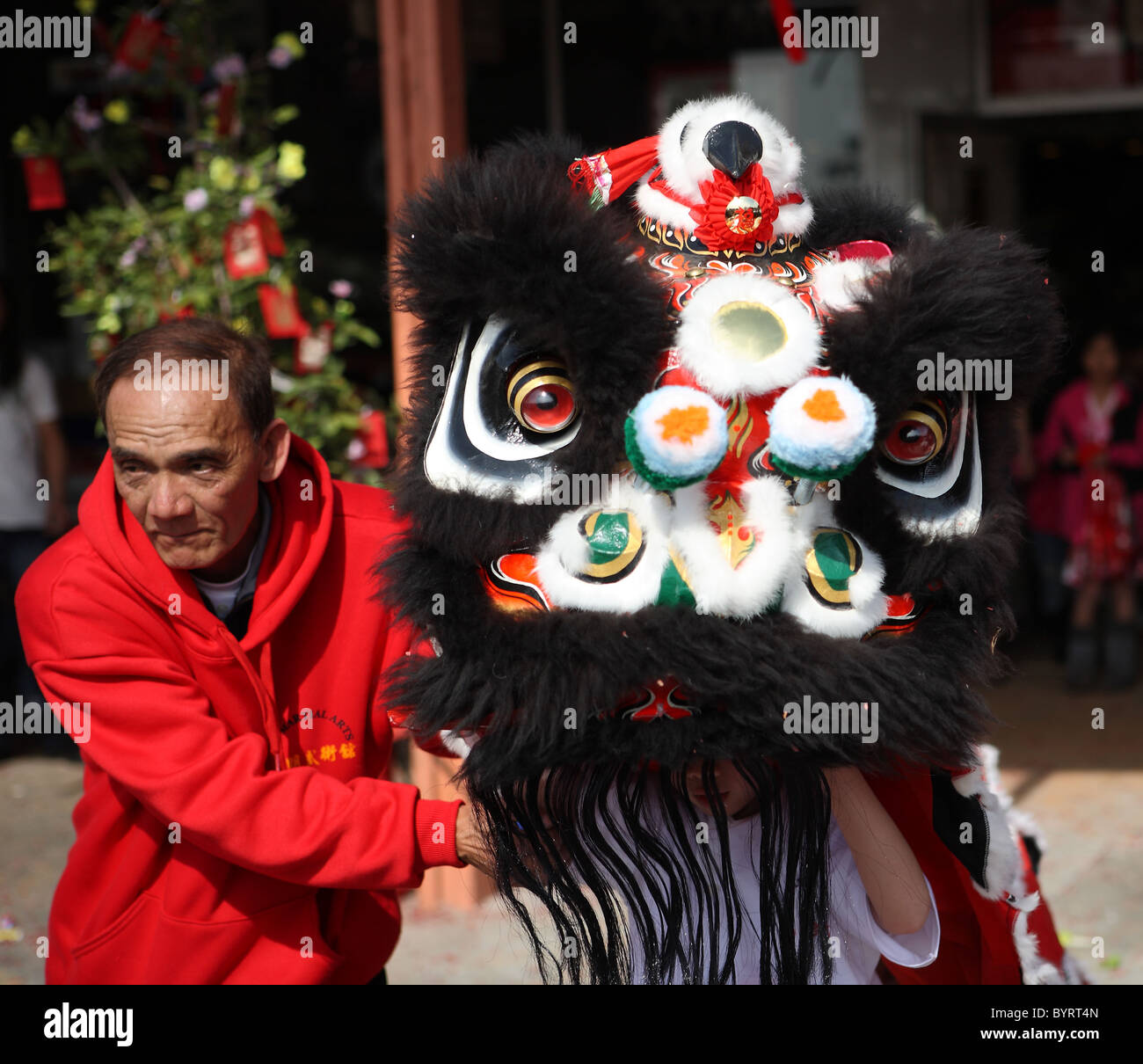 ROSEMEAD, CALIFORNIE - Le 5 février 2011 : un artiste martial senior guides un garçon dans un costume de lion de couleur pendant le Nouvel An chinois Banque D'Images