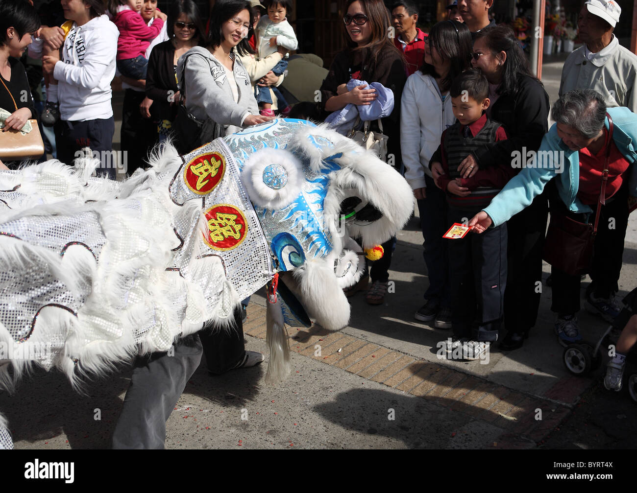 ROSEMEAD, CALIFORNIE - Le 5 février 2011 : une femme offre la chance d'argent à un lion danseur pour le Nouvel An chinois à l'extérieur d'un centre commercial Banque D'Images