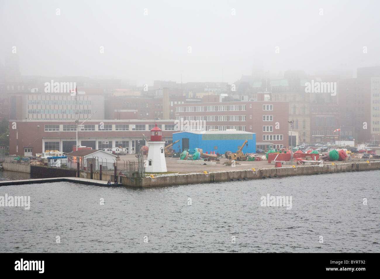 Phare à l'angle de commercial dock en un jour brumeux à port en centre-ville de Saint John, Nouveau-Brunswick, Canada Banque D'Images