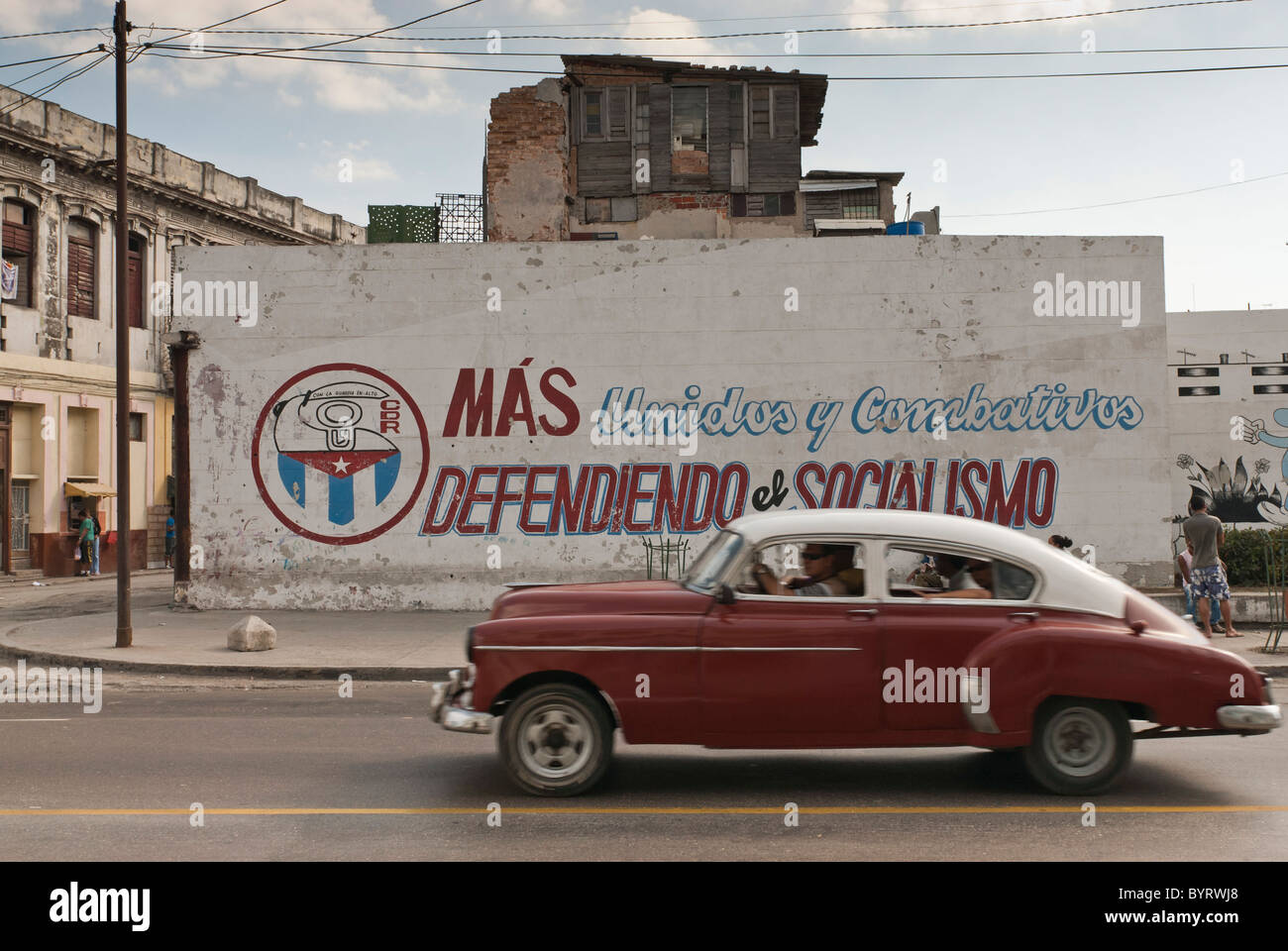 Vintage Car driving par un graffiti d'un symbole politique, La Habana, Cuba. Banque D'Images