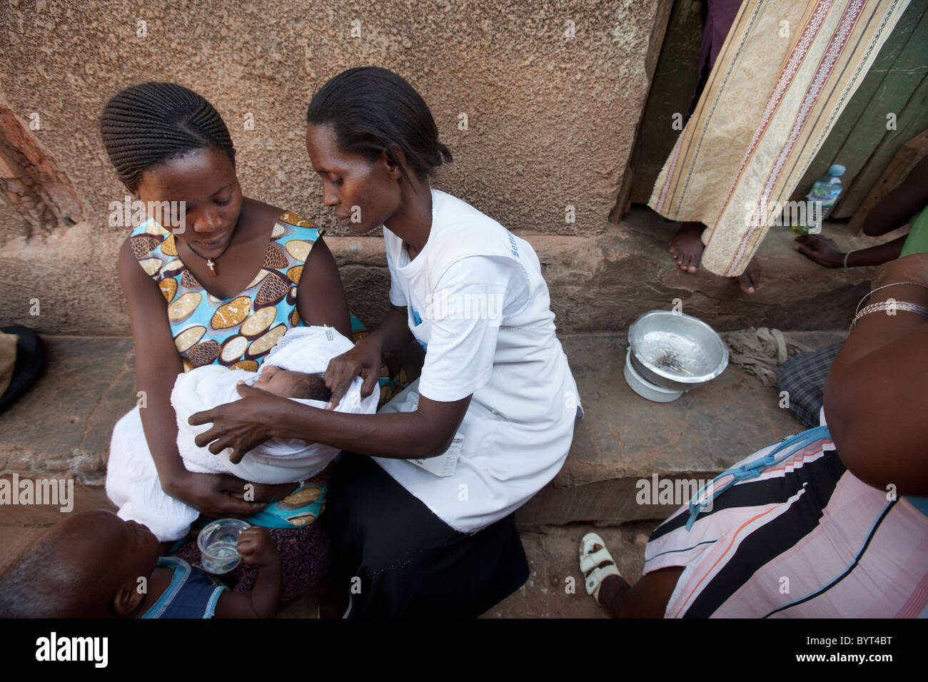 Un travailleur des services de soins de santé communautaire visite une jeune mère dans un taudis à Kampala, Ouganda, Afrique de l'Est. Banque D'Images