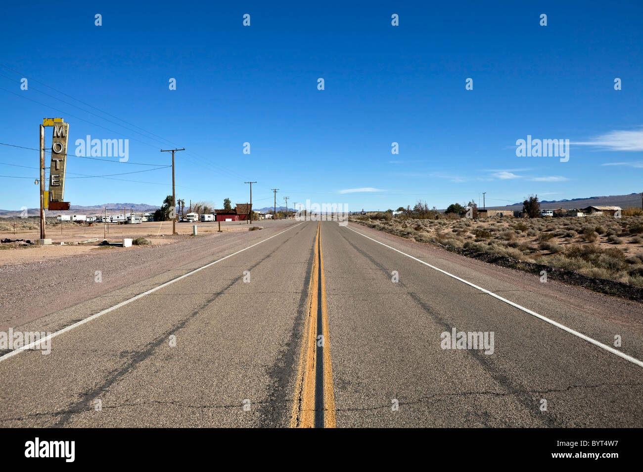 La partie décomposée de l'historique Route 66 au milieu de l'immense désert de Mojave en Californie. Banque D'Images