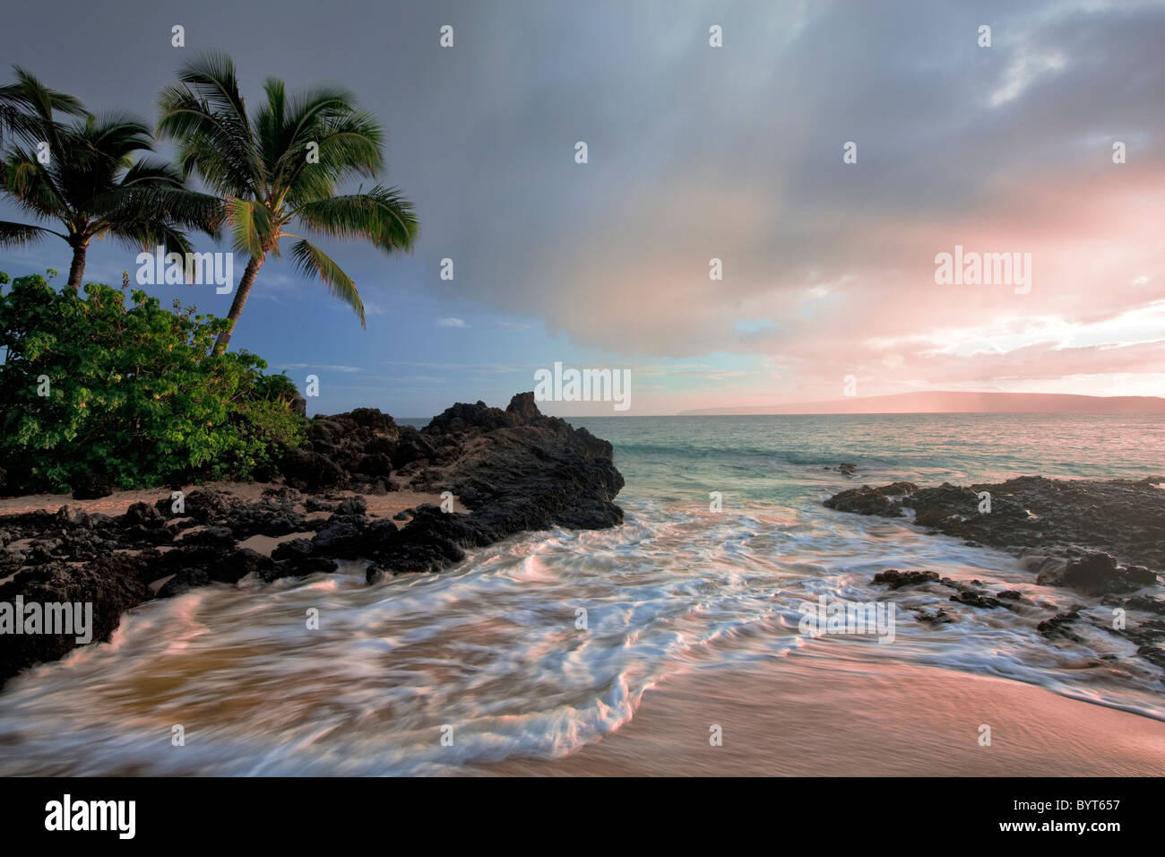 Coucher Soleil nuages et des vagues avec des palmiers. Maui, Hawaii. Banque D'Images