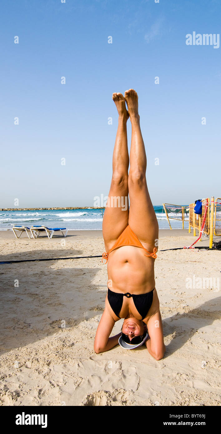 Une femme faisant du yoga sur la plage à Tel Aviv. Banque D'Images