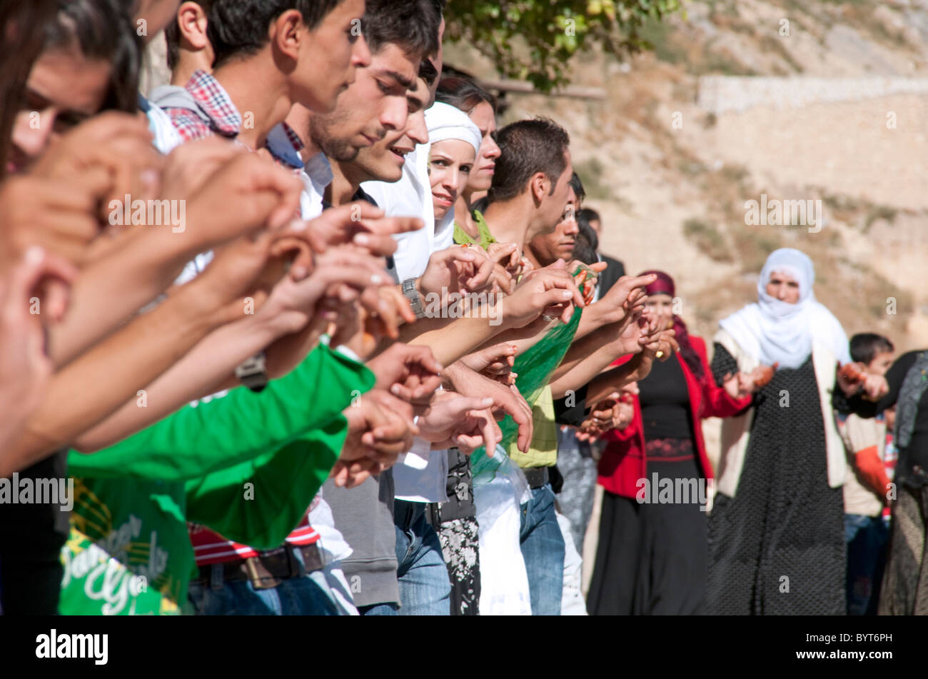 Les hommes et les femmes kurdes se tenant la main lors d'un mariage traditionnel danse cercle dans la ville de Mardin, dans le sud-est de la Turquie de la Turquie. Banque D'Images