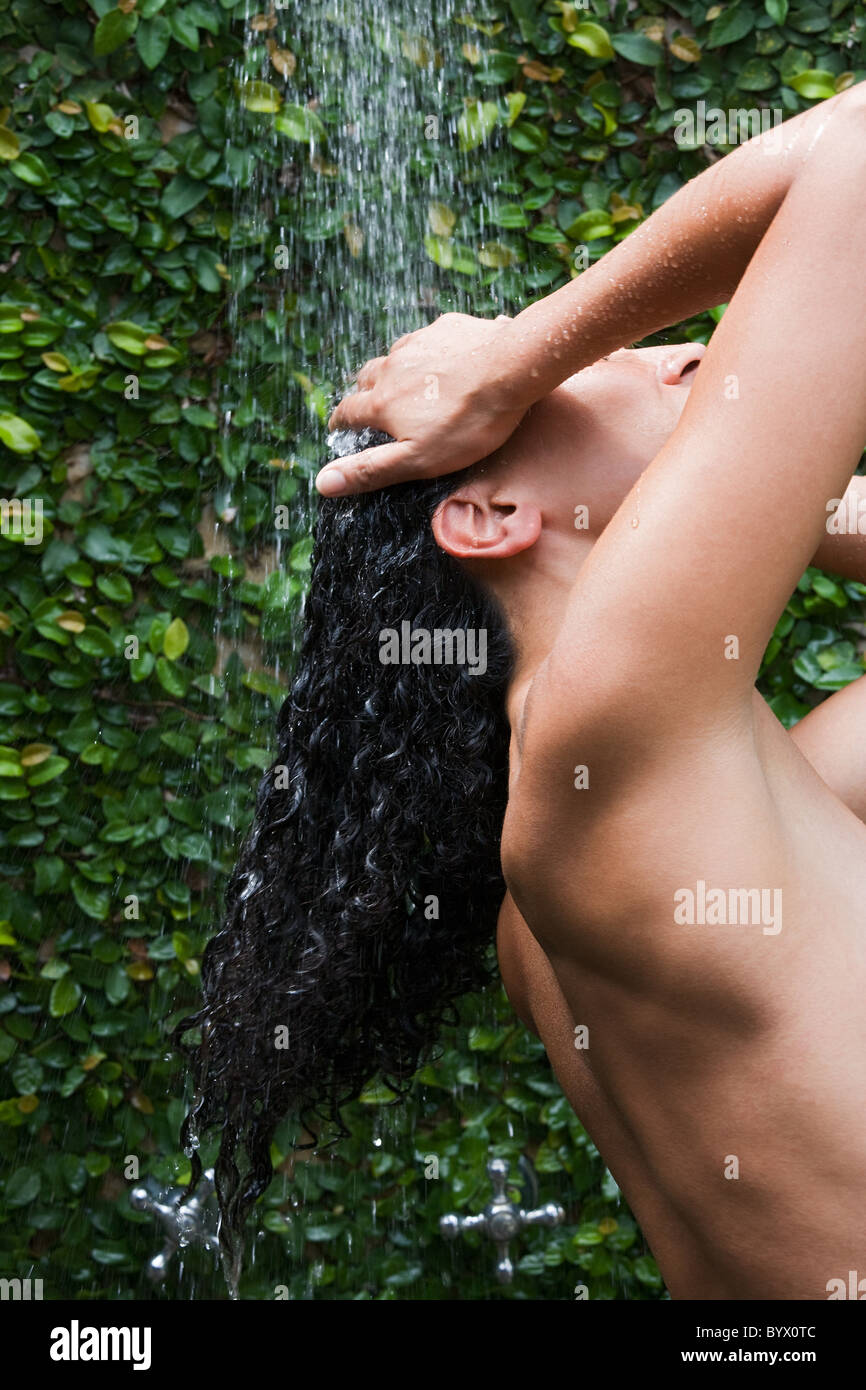 Femme dans une douche rincing ses cheveux Banque D'Images