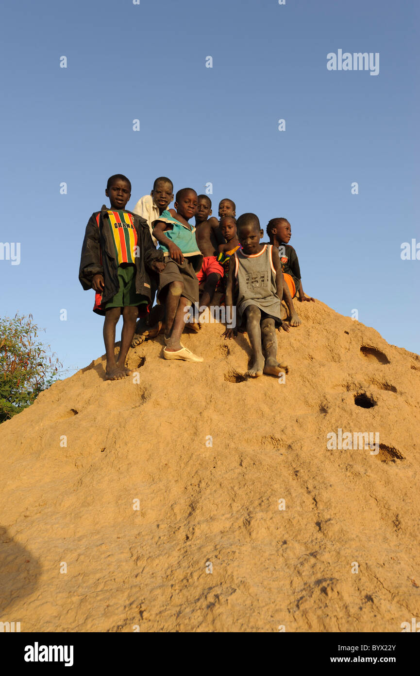 Enfants ludique en haut d'une termitière dans un village dans le Delta Intérieur du Niger. Le Mali. Banque D'Images