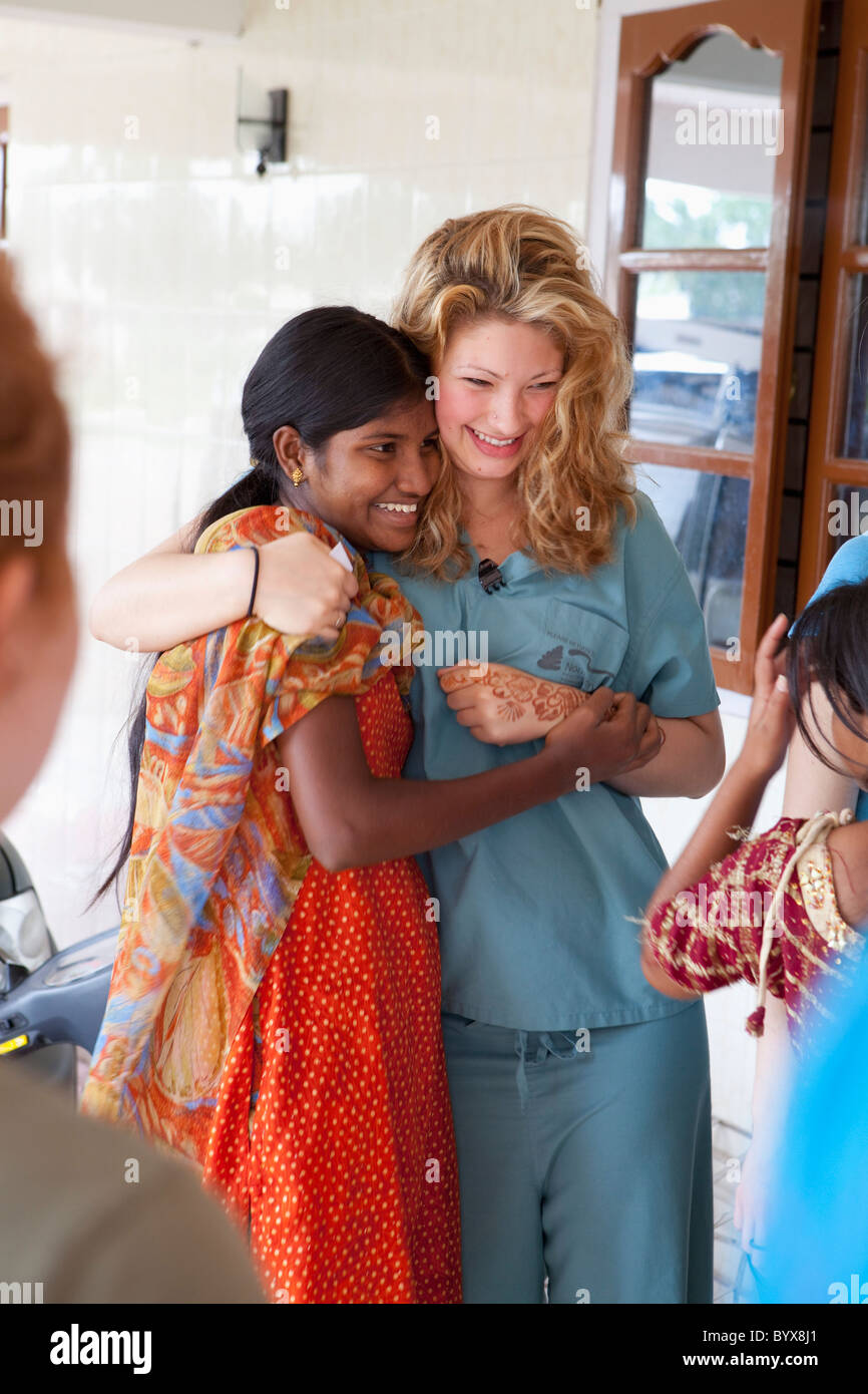 Deux jeunes femmes dans une étreinte comme l'un montre la peinture au henné sur la main ; sathyamangalam, Tamil Nadu, Inde Banque D'Images