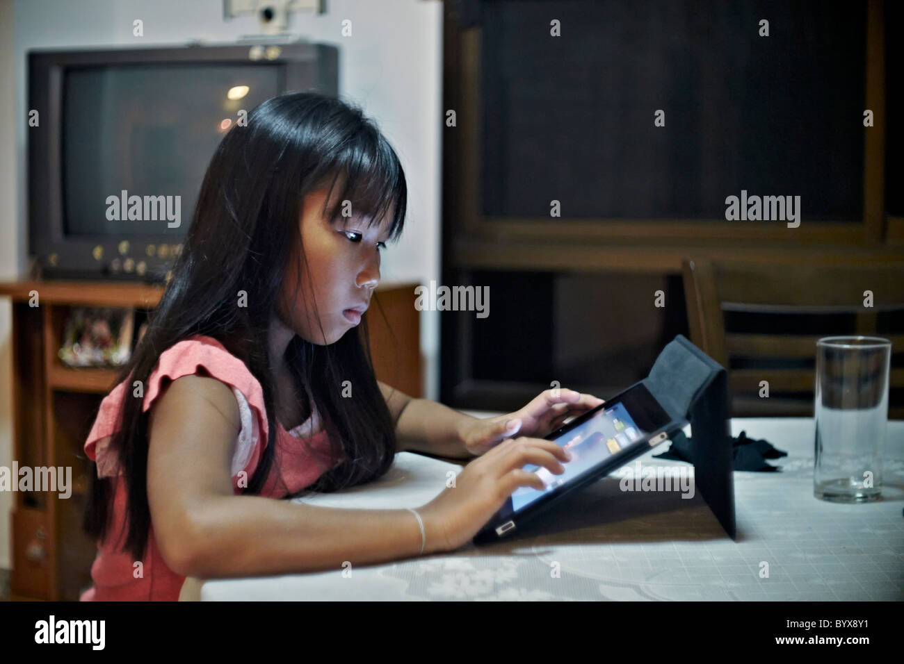 Enfant iPad. Jeune fille thaïlandaise utilisant un iPad à la maison. Thaïlande S. E. Asie Banque D'Images
