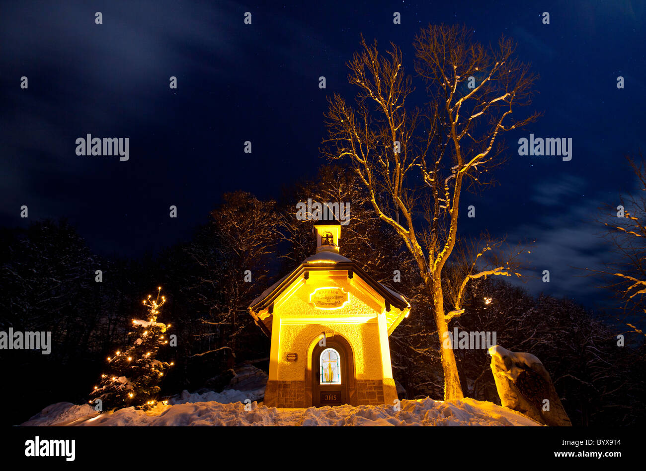 Petite chapelle au-dessus de la ville illuminée à Noël, Berchtesgaden Haute-bavière, Allemagne. Banque D'Images