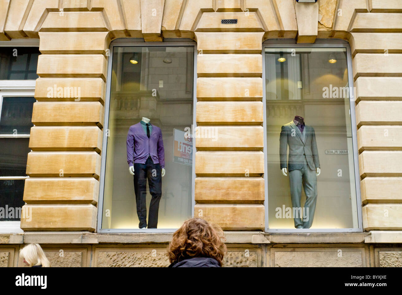 Vue humoristique de deux mannequins sans tête dans une vitrine de l'affichage et les chefs de deux personnes, England, UK Banque D'Images