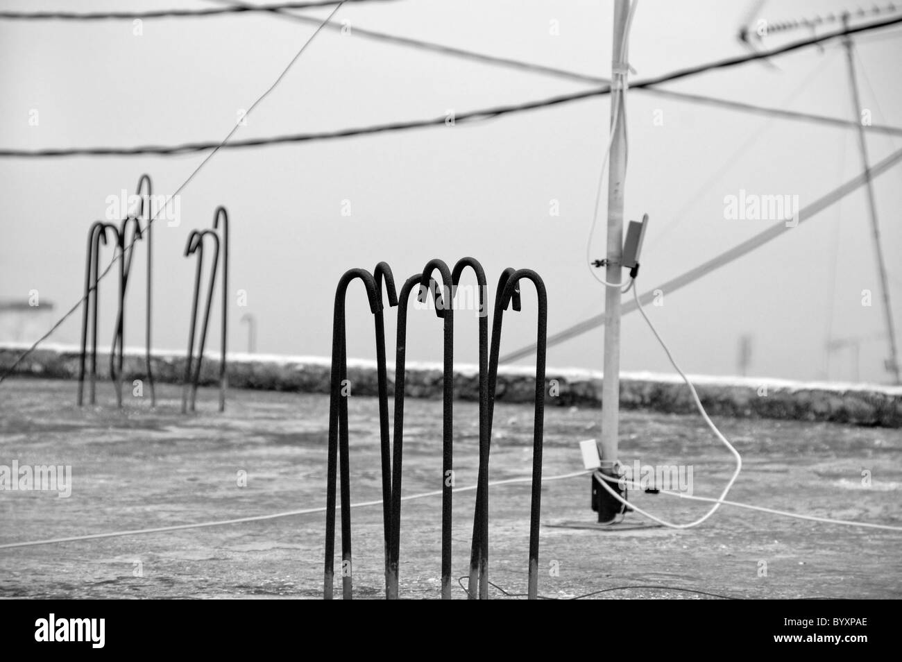 Sur le toit de la construction urbaine en béton, des bars, de l'antenne et les fils. Noir et blanc. Banque D'Images