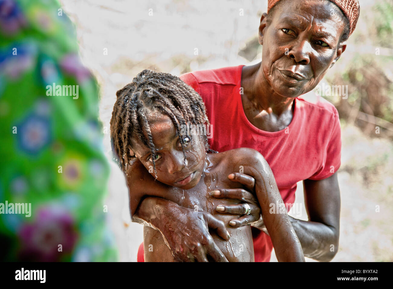 Une mère amène son enfant à la clinique qui vient de subir une saisie ; grand saline, Haïti Banque D'Images