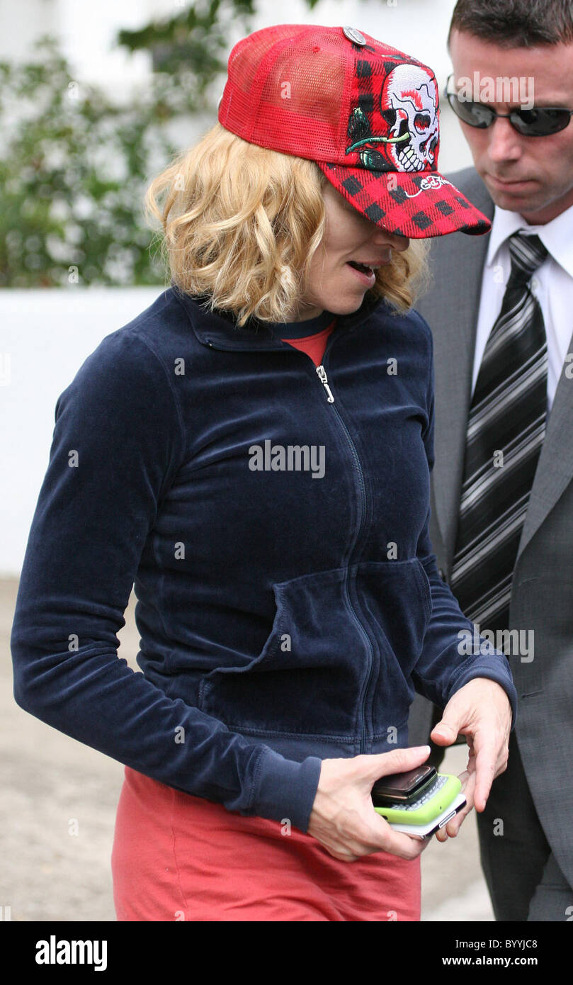 Madonna à heureux comme elle quitte son sport, vêtu d'un survêtement rouge  et noir et une casquette de baseball rouge Ed Hardy. Londres Photo Stock -  Alamy