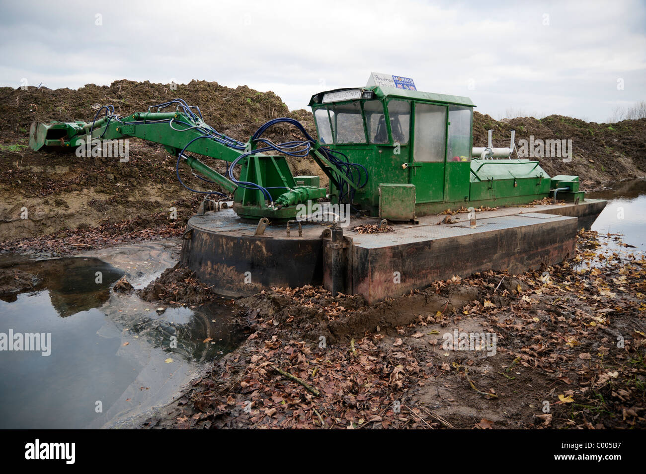 Pelle hydraulique flottante dans le canal Thames et Severn, près de South Cerney, Gloucestershire, Royaume-Uni Banque D'Images