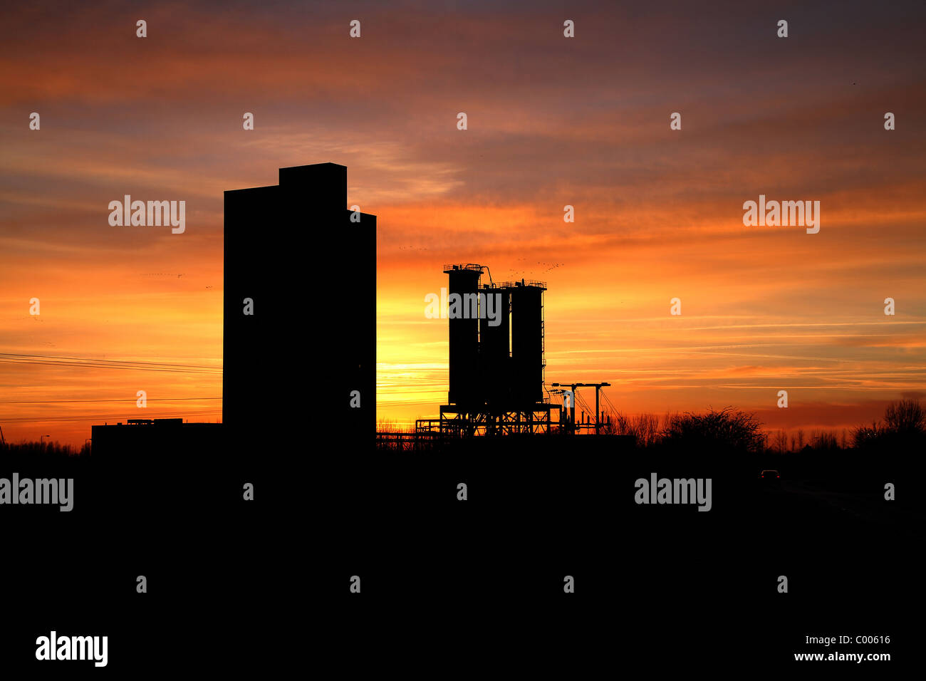 Bâtiments industriels et silos avec le coucher du soleil. Banque D'Images