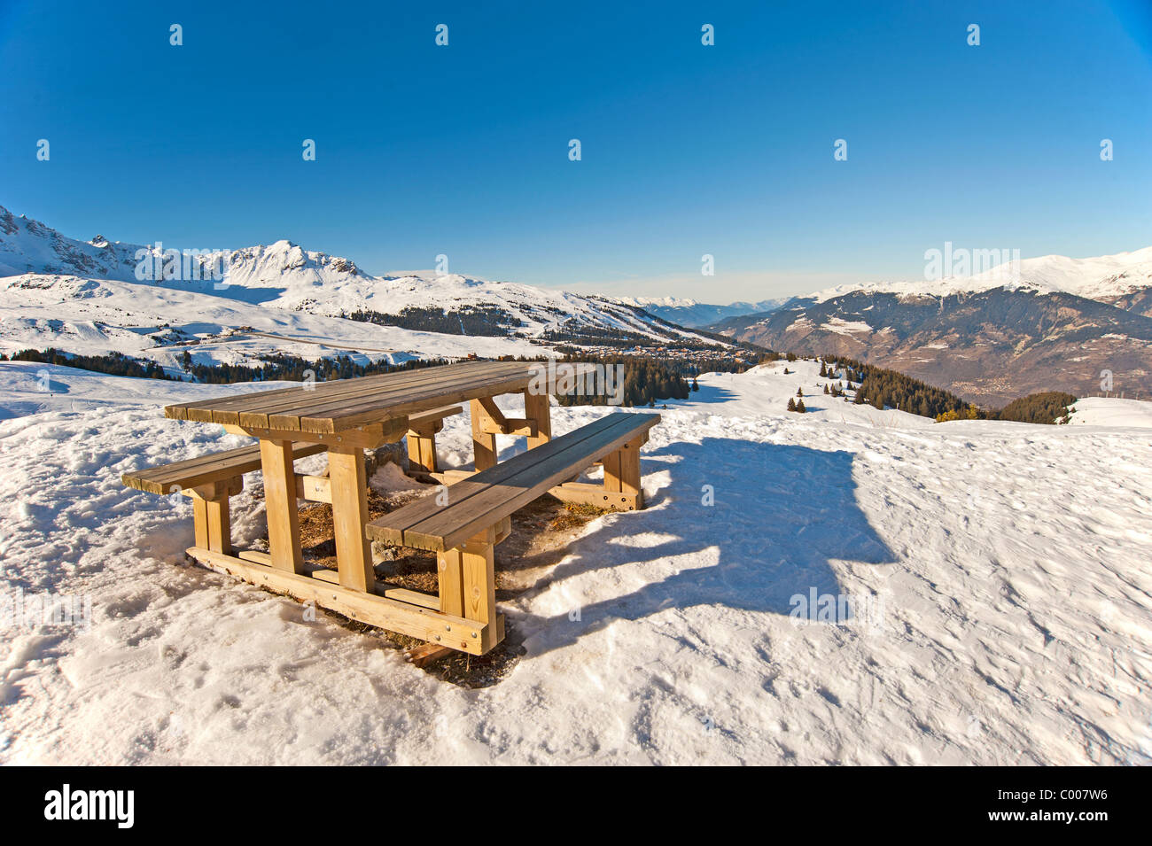 Table de pique-nique au sommet d'une montagne enneigée en vue Banque D'Images