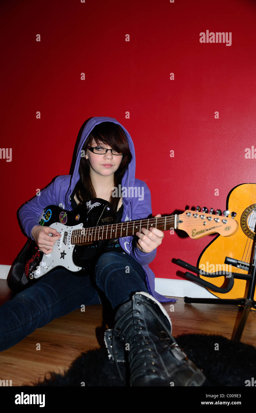 Teenage girl with guitare rock sur fond rouge Banque D'Images