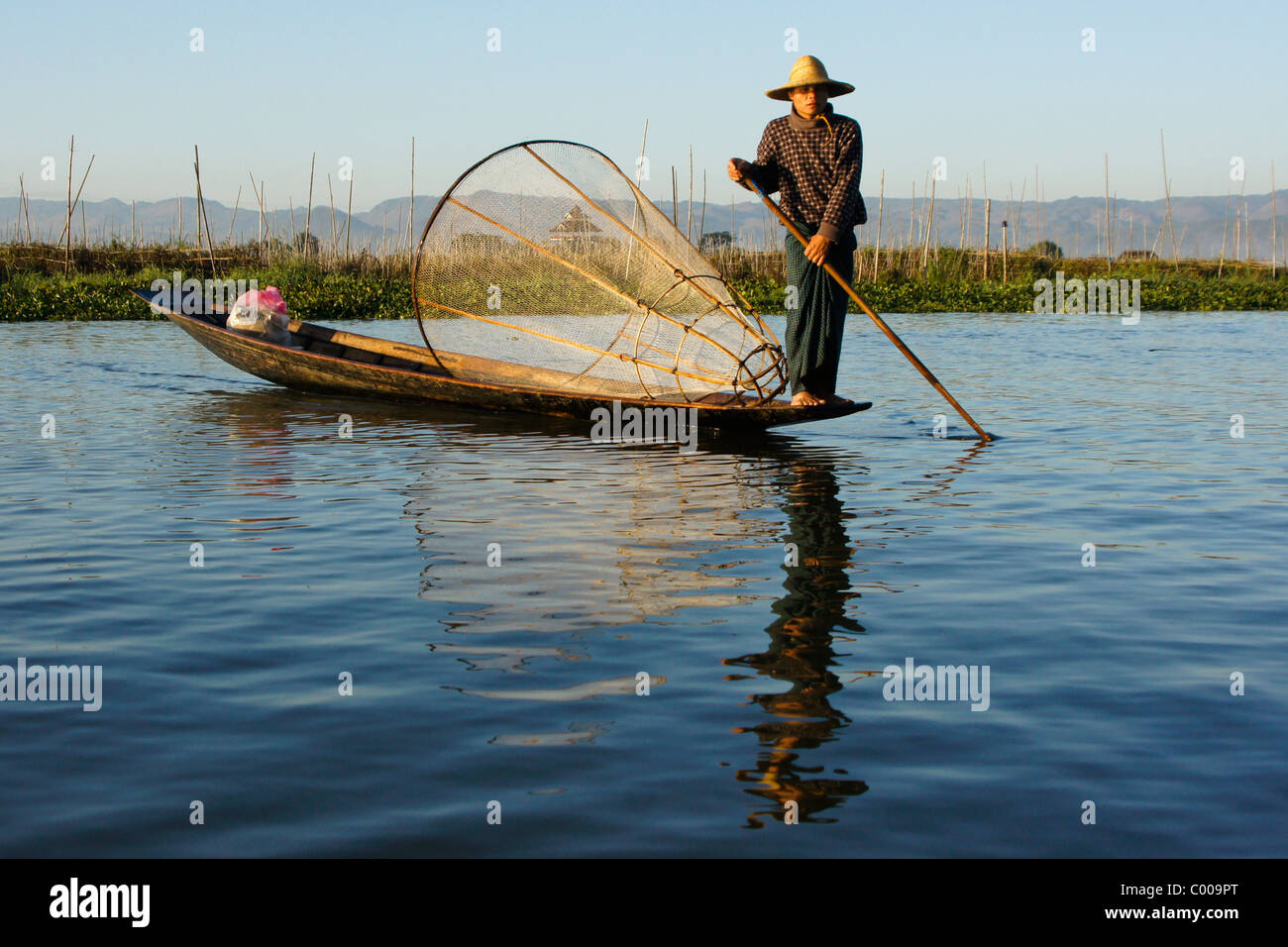 Ethnie Intha leg-pêcheur d'aviron avec panier net sur le lac Inle, Myanmar (Birmanie) Banque D'Images