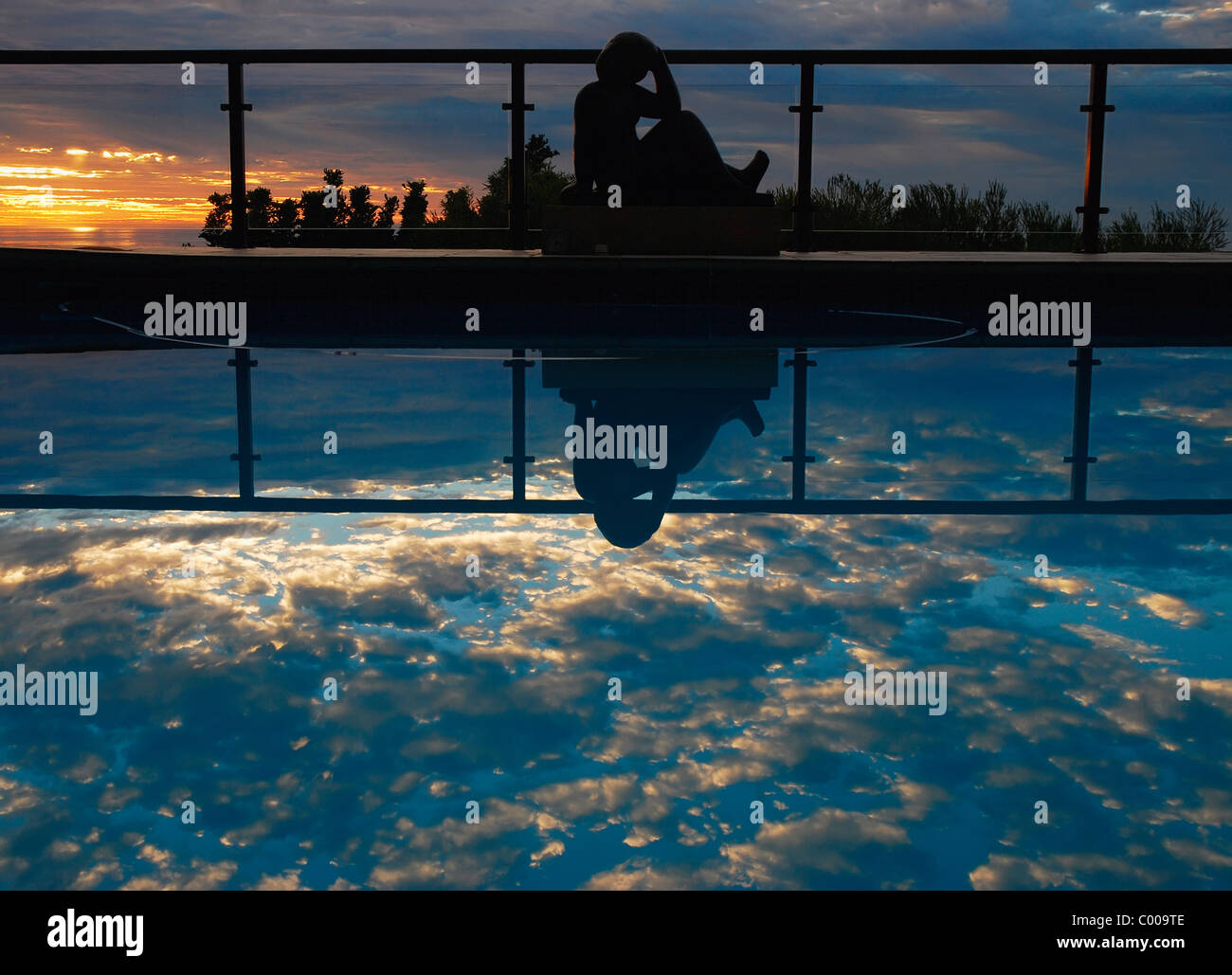 Femme reflète dans une piscine au crépuscule Banque D'Images