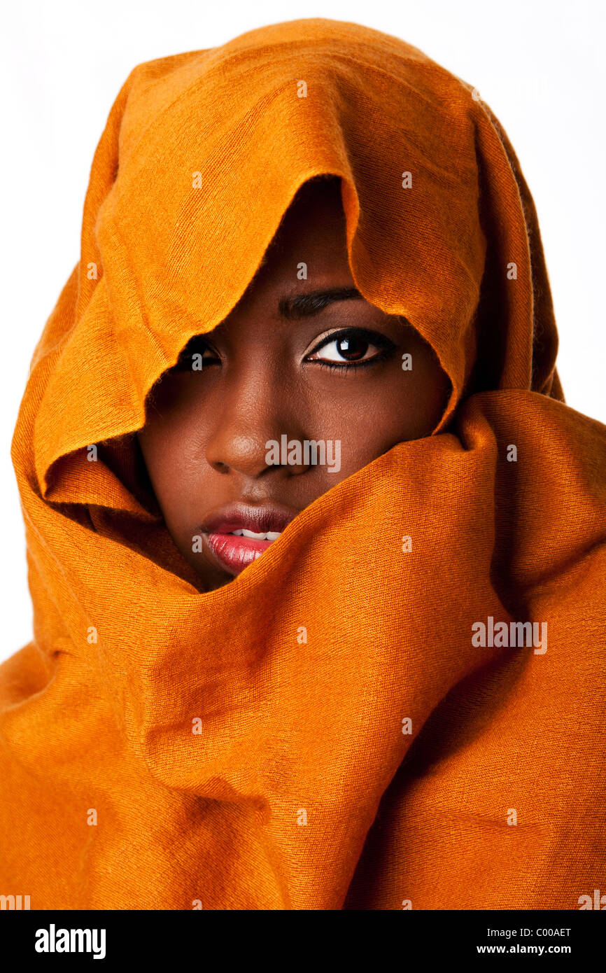 Belle africaine bédouins nomades mystérieux visage féminin dans des tons de terre ocre head wrap écharpe à la recherche. Banque D'Images
