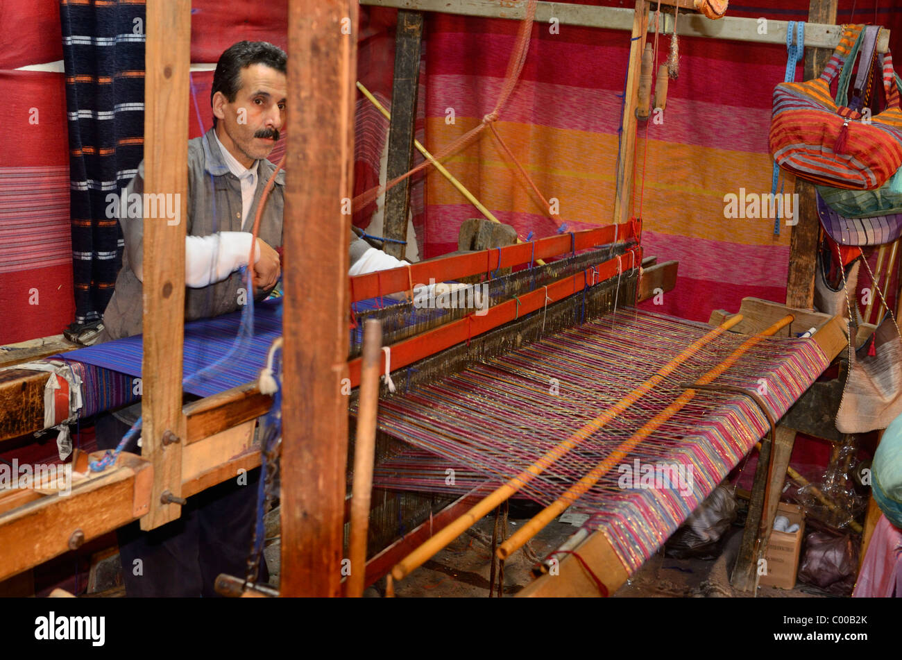 Fast Moving weaver l'exploitation d'une main en bois horizontales à tisser dans un chiffon shop Fes el Bali Medina Fès Maroc Afrique du Nord Banque D'Images