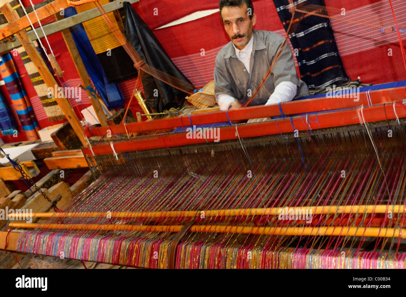 Weaver l'exploitation d'une main en bois horizontales à tisser dans un chiffon shop Fes el Bali Medina Fez Maroc Banque D'Images