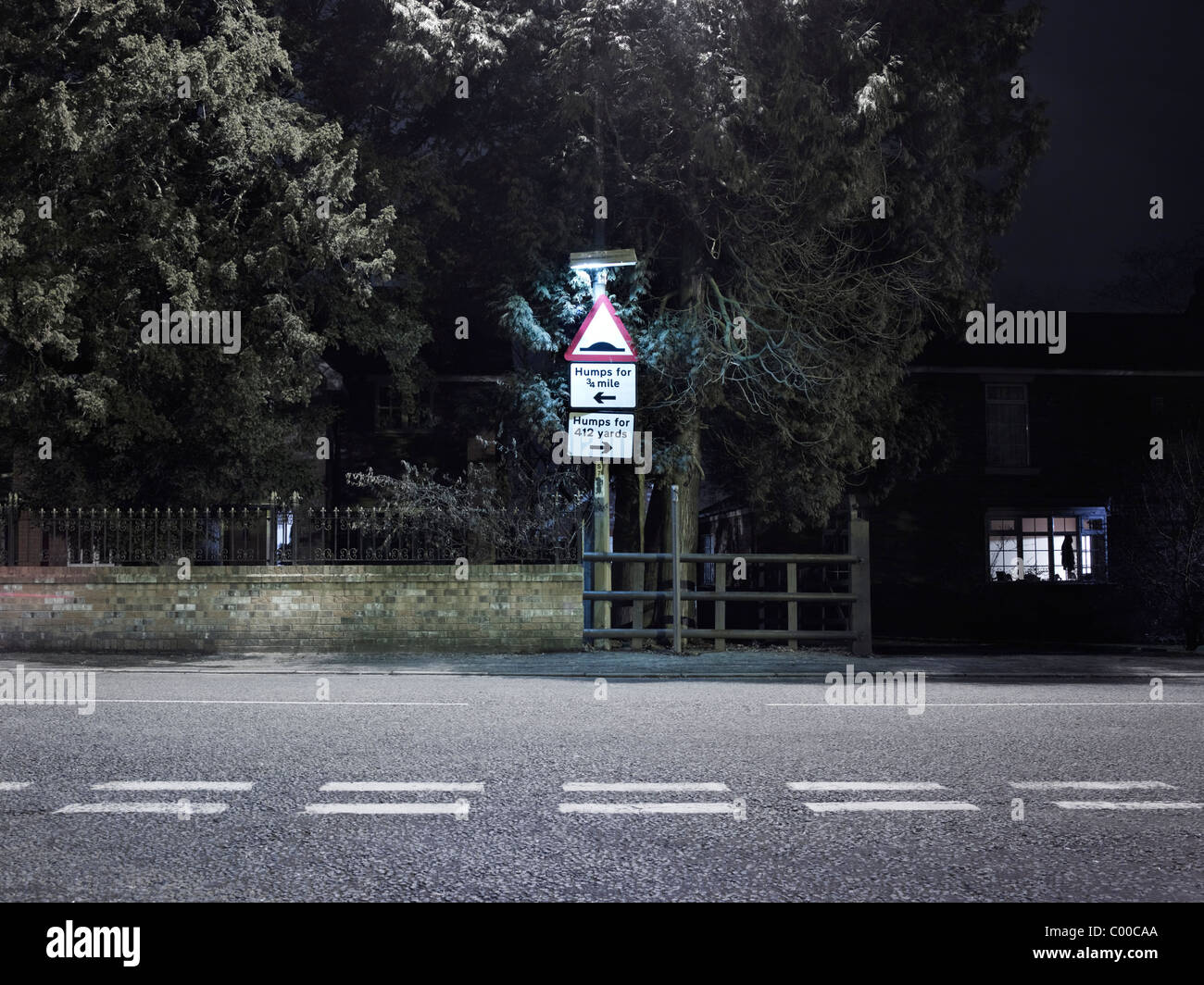 Route et arbres éclairés par des lumières de rue dans la nuit avec un ciel bleu , pris par endroits Banque D'Images