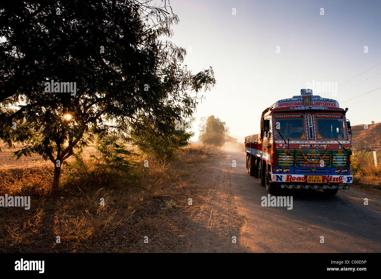 Camion transport Inde voyageant le long d'une route au lever du soleil dans la campagne indienne. L'Andhra Pradesh, Inde Banque D'Images