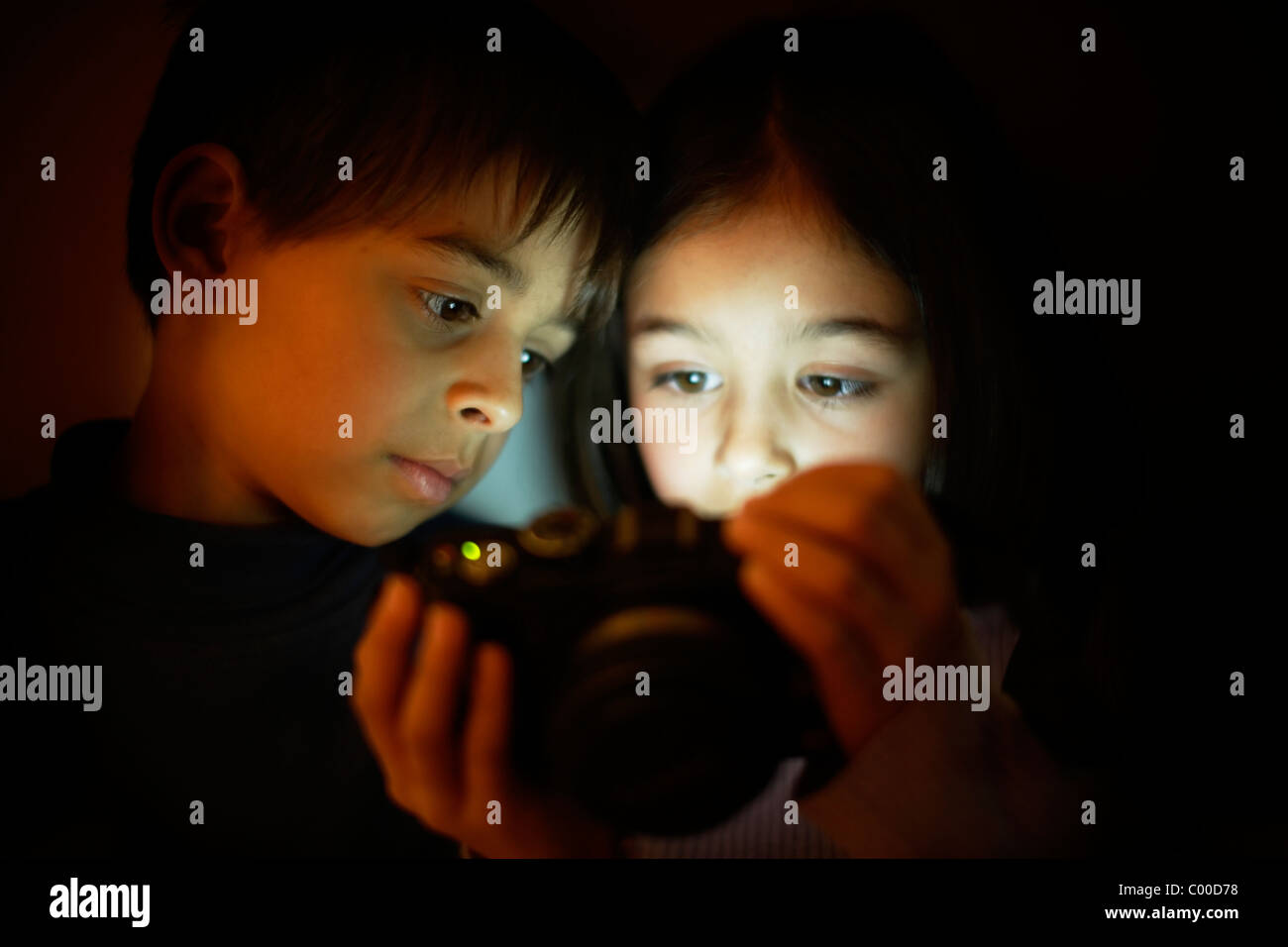 Garçon et fille regarde l'écran de l'appareil photo numérique Banque D'Images