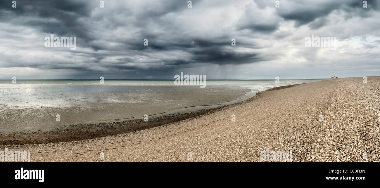 Plage de galets à Dungeness petit bateau de pêche peut être vu sur la plage de galets dans le Kent en Angleterre dormeur à distance Banque D'Images