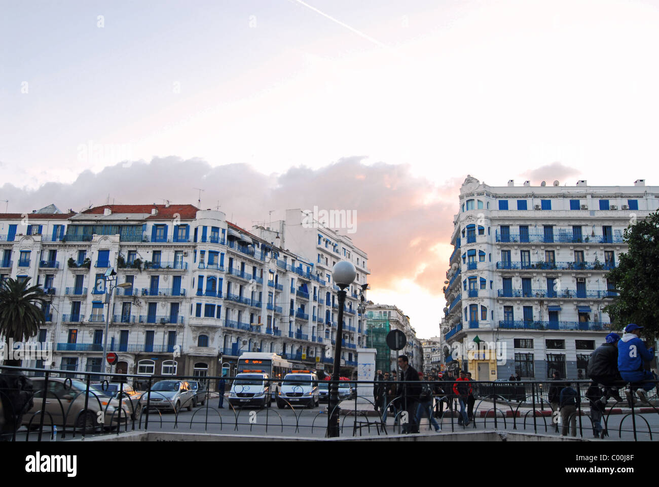 L'Algérie, Alger, de gens qui traversent la route avec des voitures et des bâtiments contre le ciel Banque D'Images L'Algérie, Alger, de gens qui traversent la route avec des voitures et des bâtiments contre le ciel Banque D'Images